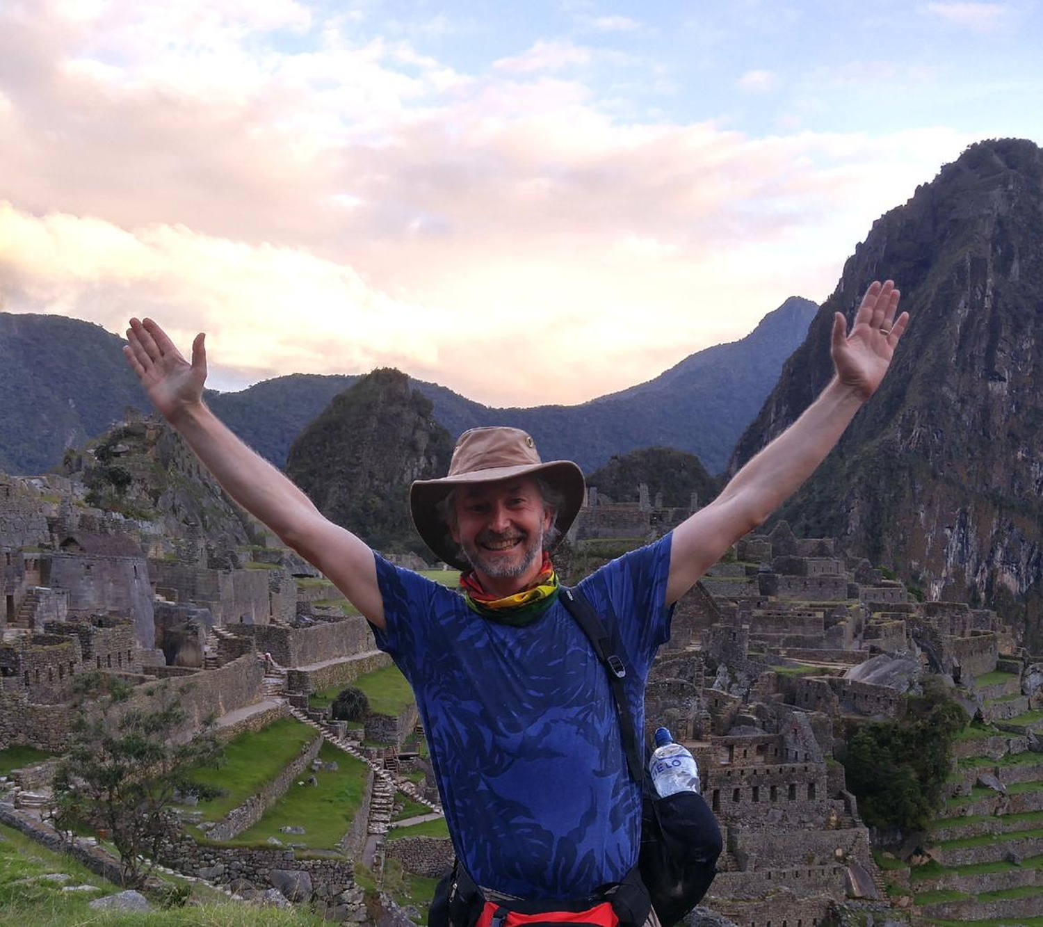 Todd with arms raised at Machu Picchu at dawn