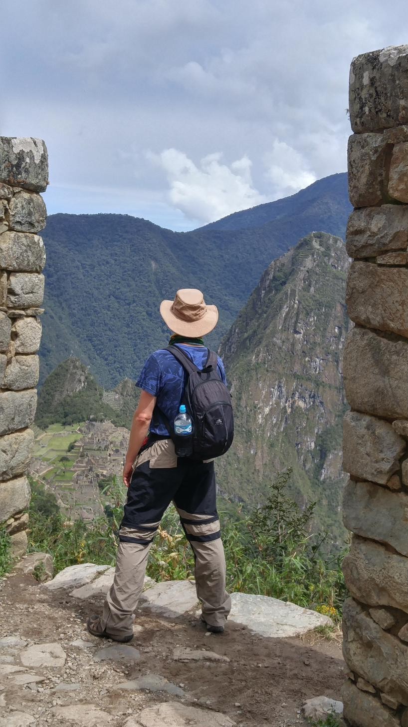 Todd standing in a stone Incan doorway looking out over Machu Picchu and the mountains